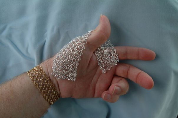 Chain mail section draped over hand.
