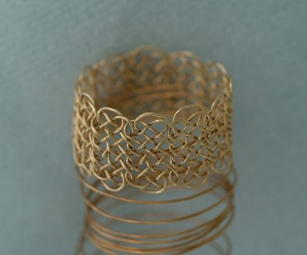 Knotted chain ring, 12 3-loop prolong knots, on spring.